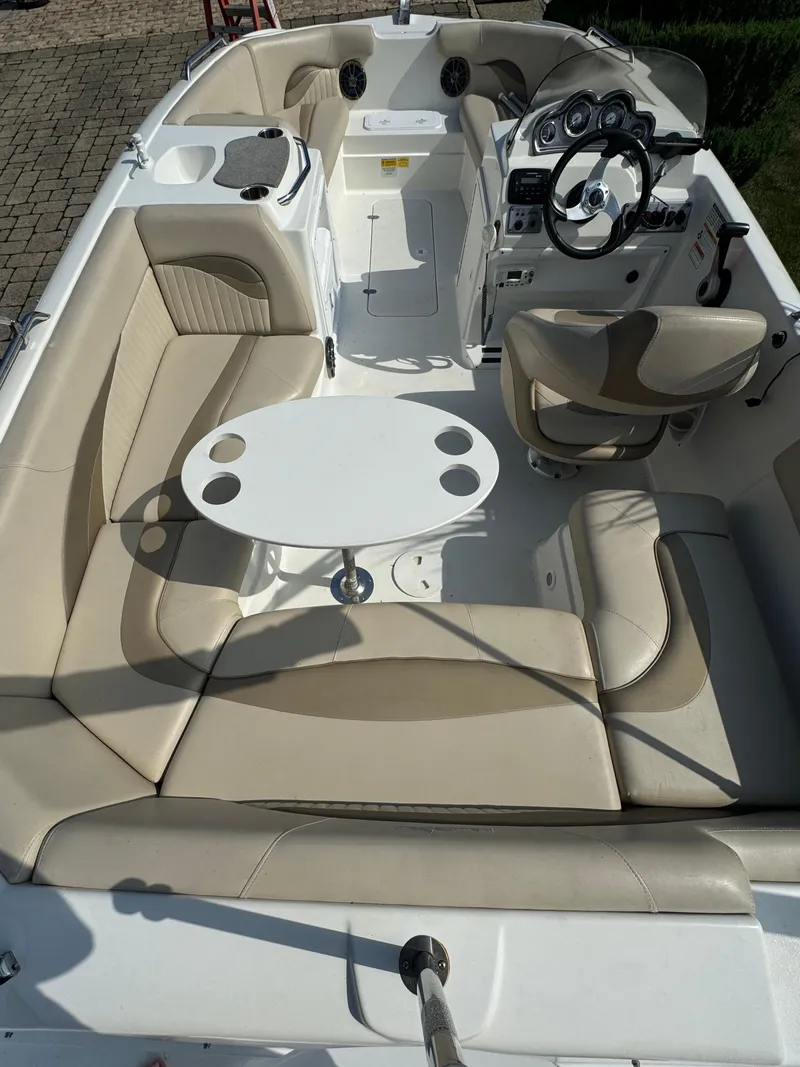 Slide: The Image of 2014 NauticStar 203SC Sport Deck boat interior with beige seating and a central table. - 5