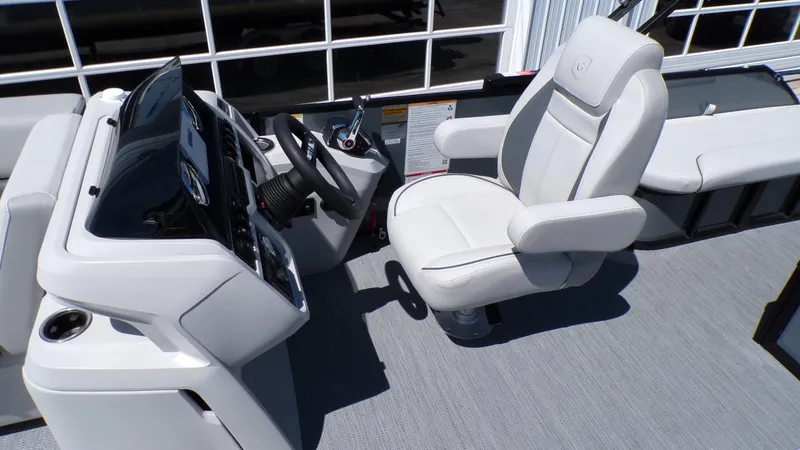 Slide: The Image of Captain's seat and helm of 2025 Godfrey Sweetwater 2486 SFLC boat, featuring modern controls. - 15