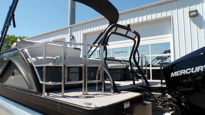 Slide: The Image of 2025 Godfrey Sweetwater 2486 SFLC pontoon boat with Mercury engine, docked near a building. - 4