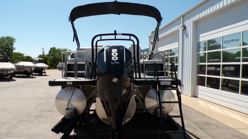 Slide: The Image of 2025 Godfrey Sweetwater 2486 SFLC pontoon boat with 200 V6 engine, parked outside. - 5