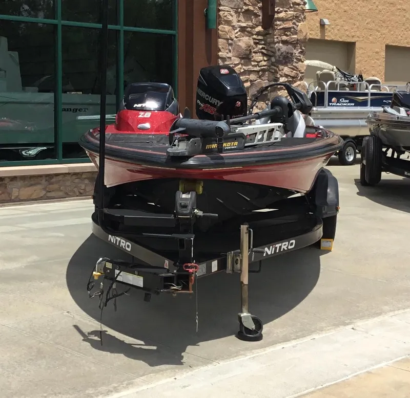 Slide: The Image of 2013 Nitro Z8 boat on trailer, parked outdoors, featuring Mercury engine and Minn Kota trolling motor. - 2