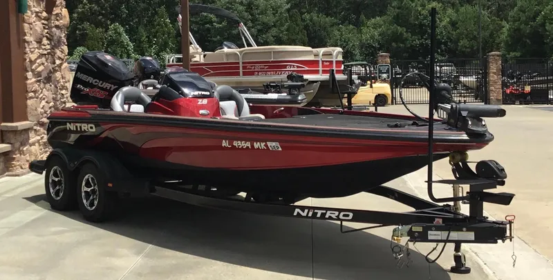 Slide: The Image of 2013 Nitro Z8 boat on trailer, red and black, parked outdoors. - 4