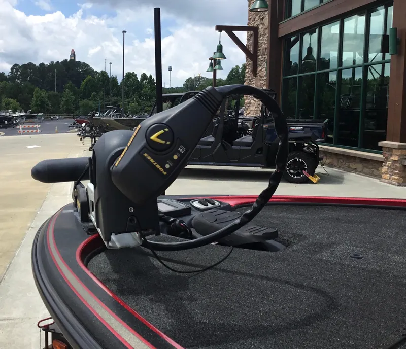 Slide: The Image of 2013 Nitro Z8 boat with trolling motor, parked outside a building on a sunny day. - 6