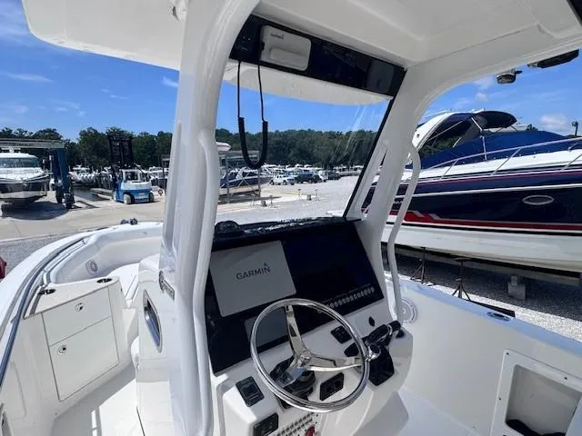 Slide: The Image of Edgewater 262CC 2017 boat cockpit with Garmin navigation, docked among other boats. - 11