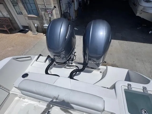 Slide: The Image of 2017 Edgewater 262CC boat with dual 200 horsepower engines, docked in a marina. - 14