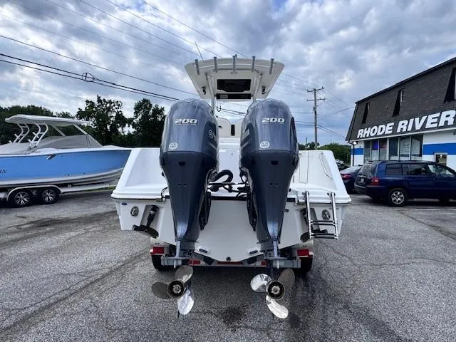 Slide: The Image of 2017 Edgewater 262CC boat with dual 200 horsepower engines, parked outdoors. - 5