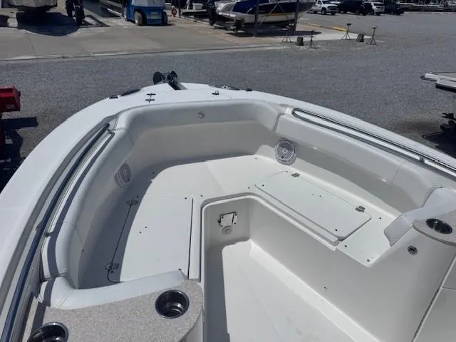 Slide: The Image of 2017 Edgewater 262CC boat interior with seating and storage, docked in a marina. - 7