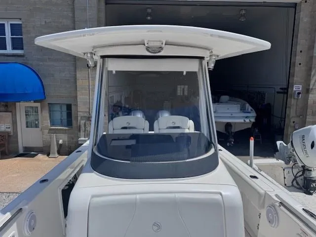 Slide: The Image of 2017 Edgewater 262CC boat with dual seats, docked near a building. - 8