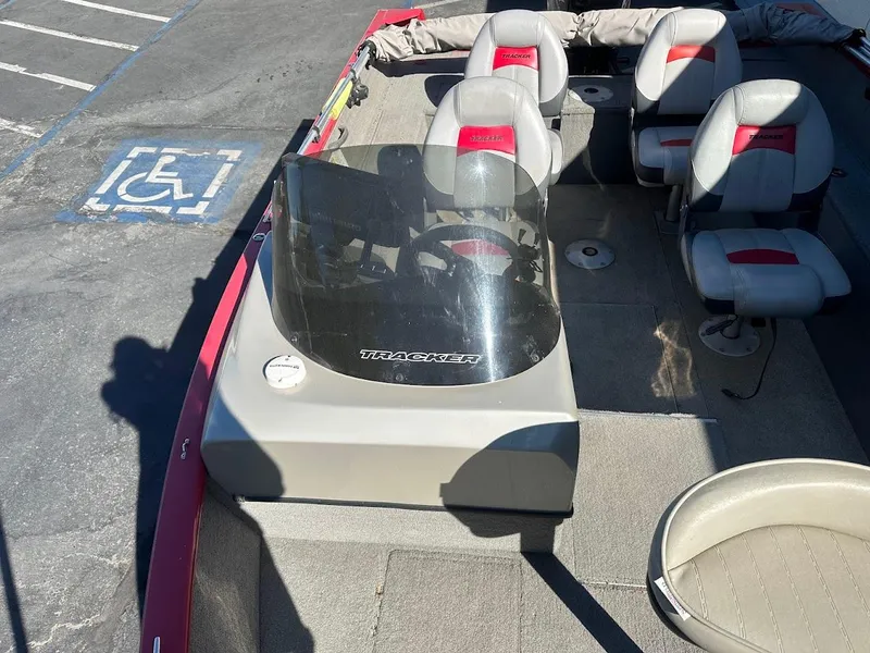 Slide: The Image of 2013 Tracker Pro Guide V-175 SC boat interior with seating and console, parked in a lot. - 27