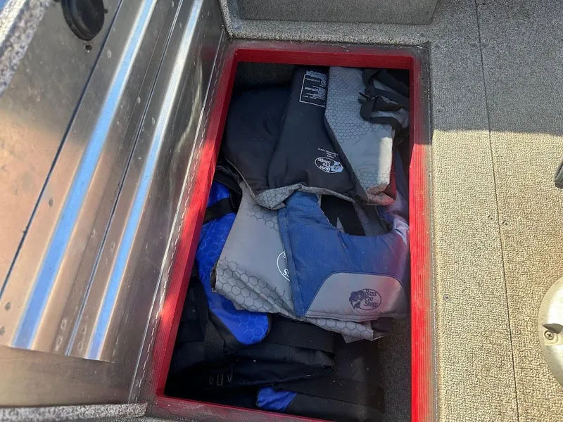 Slide: The Image of Storage compartment with life jackets in a 2013 Tracker Pro Guide V-175 SC boat. - 33