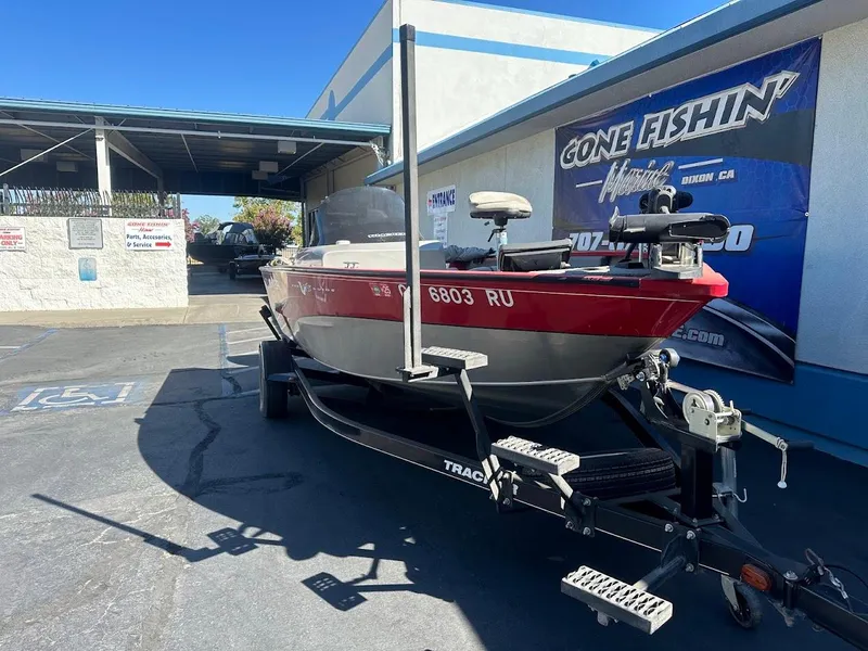 Slide: The Image of 2013 Tracker Pro Guide V-175 SC boat on trailer at dealership, sunny day. - 5