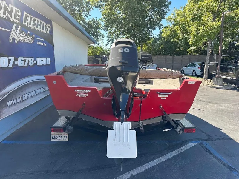 Slide: The Image of 2013 Tracker Pro Guide V-175 SC boat with 90 HP motor, parked outdoors. - 9