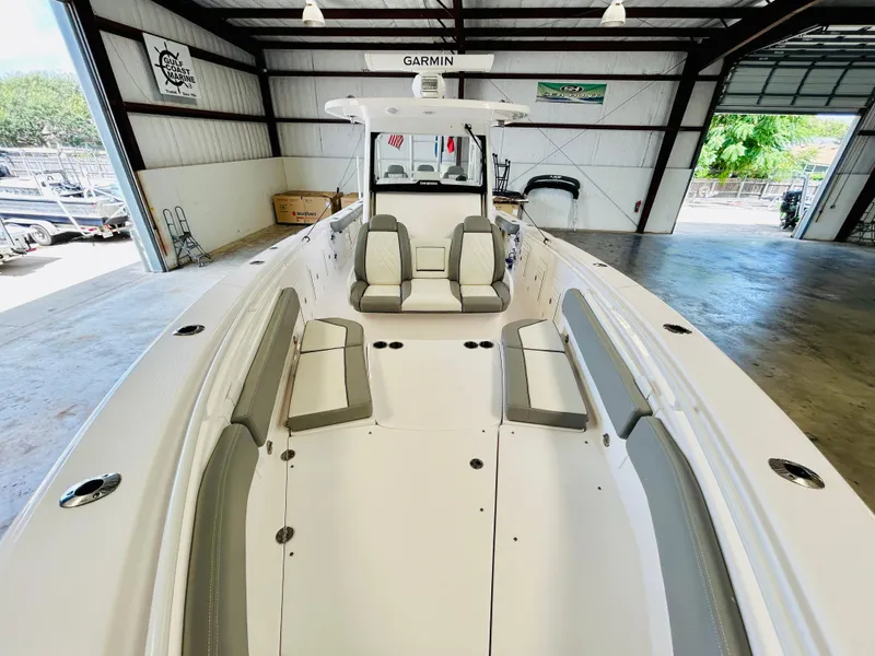 Slide: The Image of 2022 Everglades 365 Center Console boat interior with seating, in a spacious garage. - 10