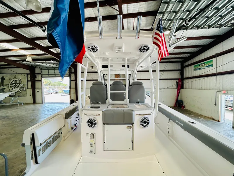 Slide: The Image of 2022 Everglades 365 Center Console boat in a marine warehouse, featuring flags and seating. - 13