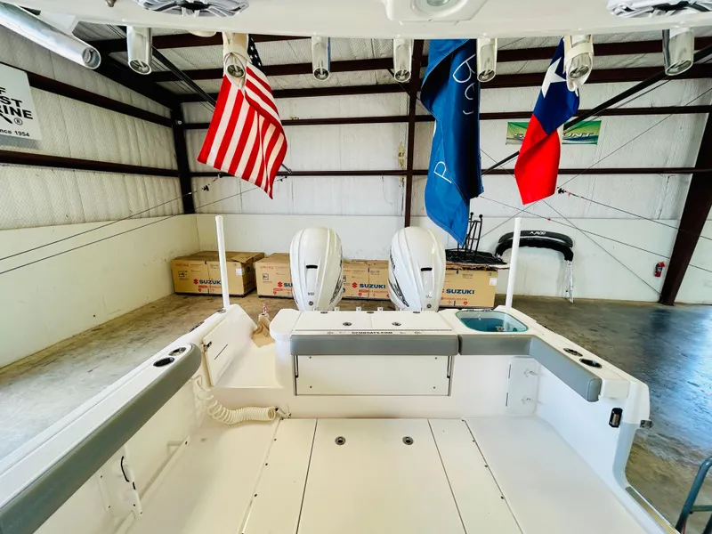 Slide: The Image of 2022 Everglades 365 Center Console boat in warehouse with flags and Suzuki boxes. - 15