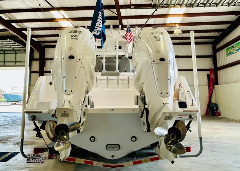 Slide: The Image of 2022 Everglades 365 Center Console boat with dual outboard engines in a warehouse. - 8