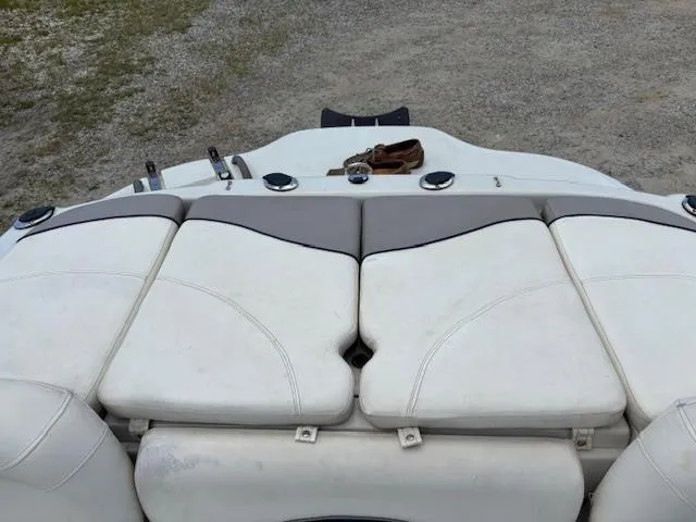 Slide: The Image of 2006 Tahoe Q4 Sport Fish boat with white cushioned seating, parked on gravel. - 16