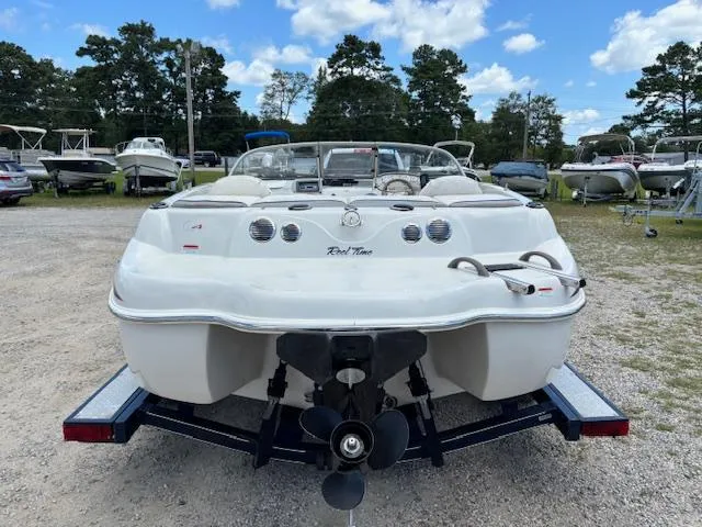 Slide: The Image of 2006 Tahoe Q4 Sport Fish boat on trailer, parked in a marina with other boats. - 4