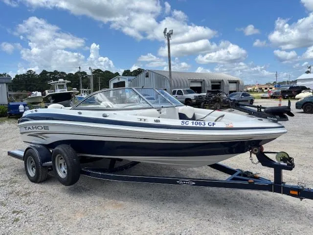Slide: The Image of 2006 Tahoe Q4 Sport Fish boat on trailer, parked outdoors under a blue sky. - 7
