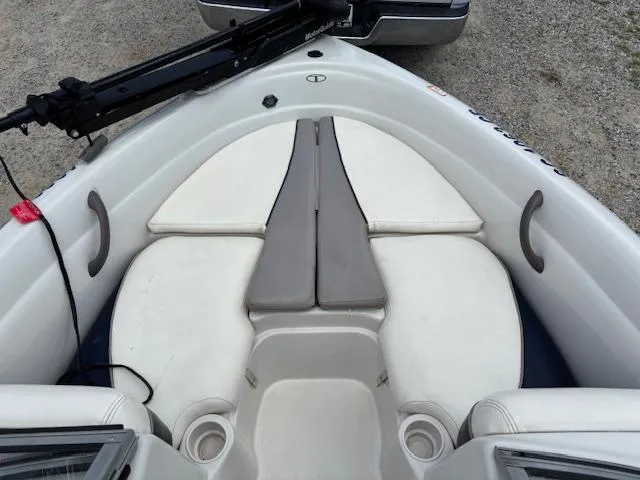 Slide: The Image of 2006 Tahoe Q4 Sport Fish boat interior with white cushioned seating and cup holders. - 9