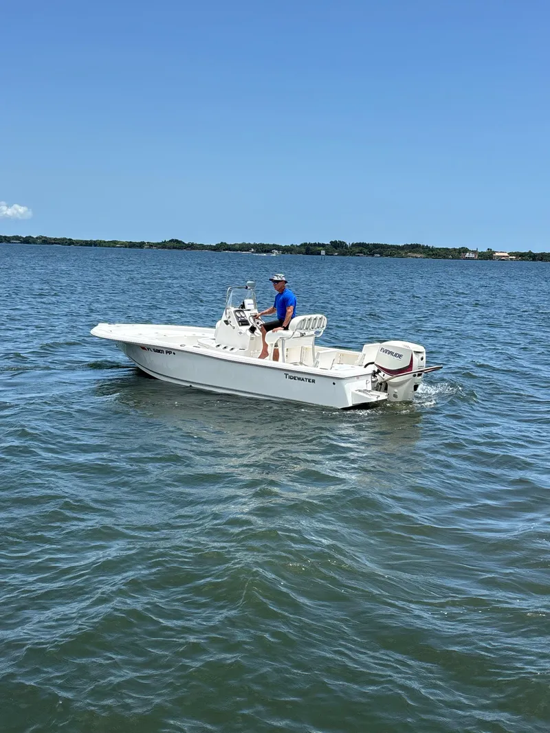 Slide: The Image of 2014 Tidewater 2000 Carolina Bay boat on open water, clear sky, person seated at helm. - 4