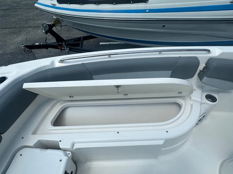 Slide: The Image of 2023 NauticStar 251 Hybrid boat interior with gray seating and console, parked outdoors. - 16