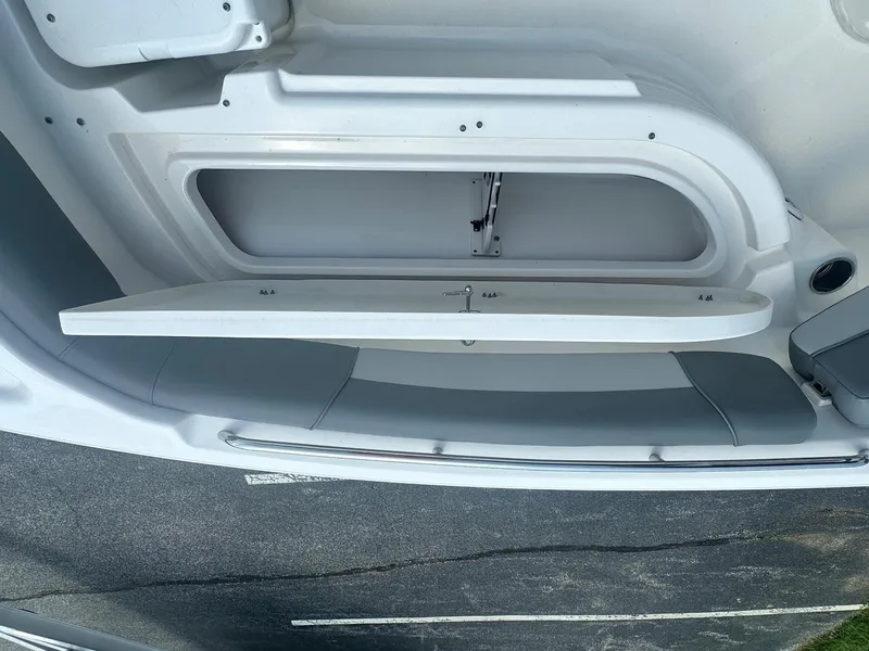 Slide: The Image of 2023 NauticStar 251 Hybrid boat with spacious seating and table in a marina setting. - 17