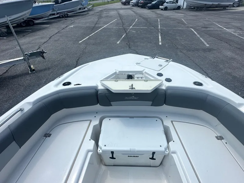 Slide: The Image of 2023 NauticStar 251 Hybrid boat interior with open storage compartment and cushioned seating. - 19
