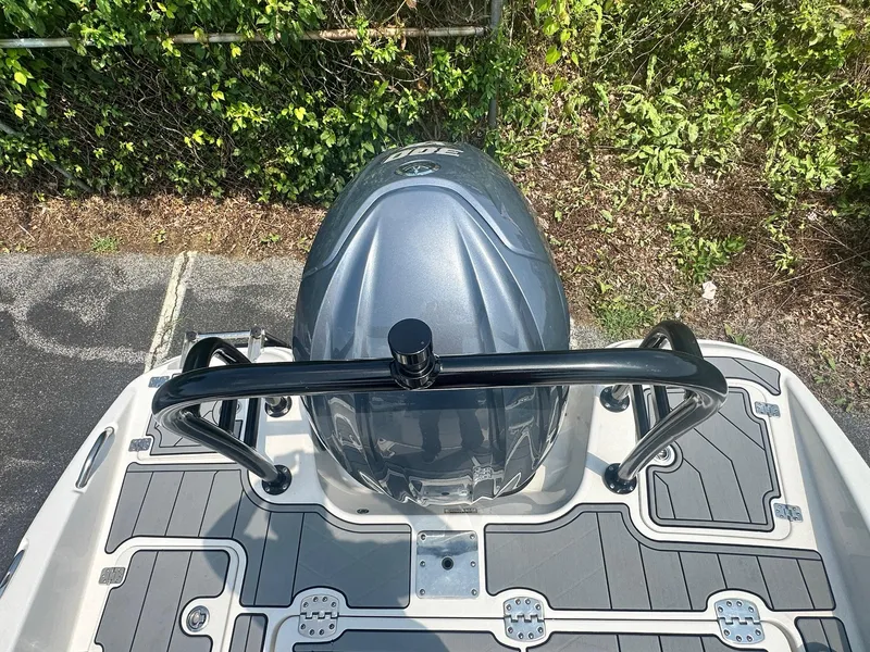 Slide: The Image of 2023 NauticStar 251 Hybrid boat with T-top and rod holders in a marina setting. - 25