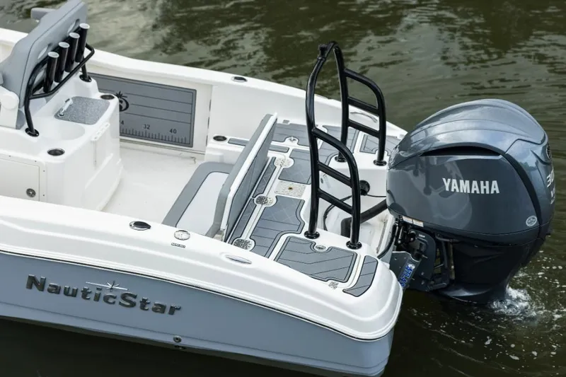 Slide: The Image of 2023 NauticStar 251 Hybrid boat on trailer, parked outdoors with autumn trees. - 3