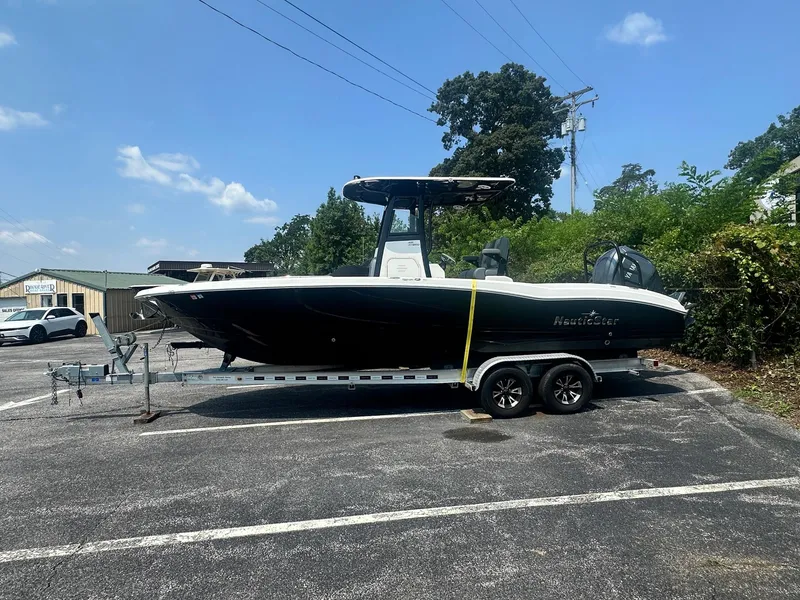 Slide: The Image of 2023 NauticStar 251 Hybrid boat in a dealership lot under a clear sky. - 32