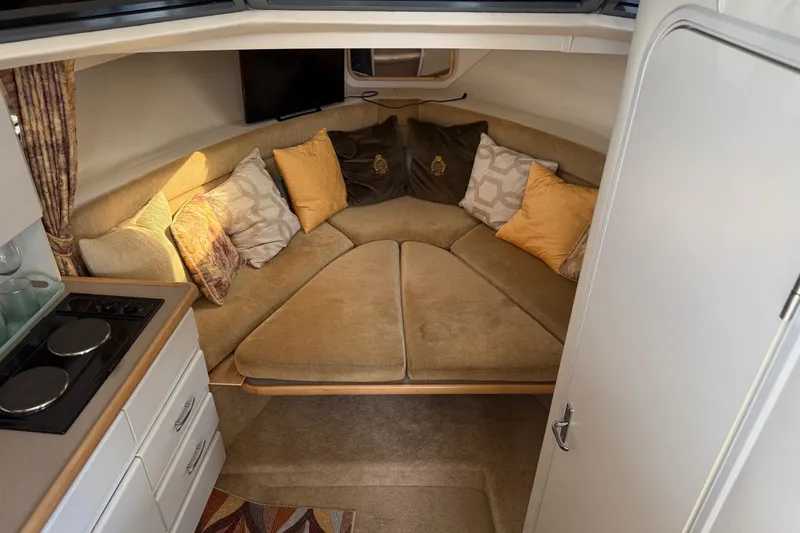 Slide: The Image of 1995 Carver 325 Aft Cabin interior with cozy seating and decorative pillows. - 12