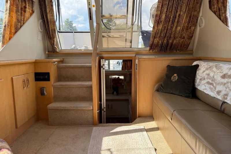 Slide: The Image of Interior of 1995 Carver 325 Aft Cabin with stairs, sofa, and decorative pillows. - 14