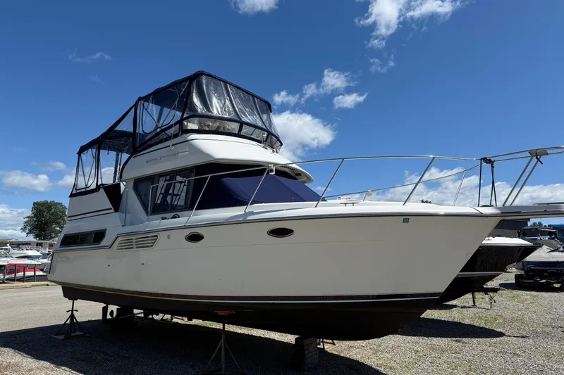 Slide: The Image of 1995 Carver 325 Aft Cabin boat on stands under a clear blue sky. - 18