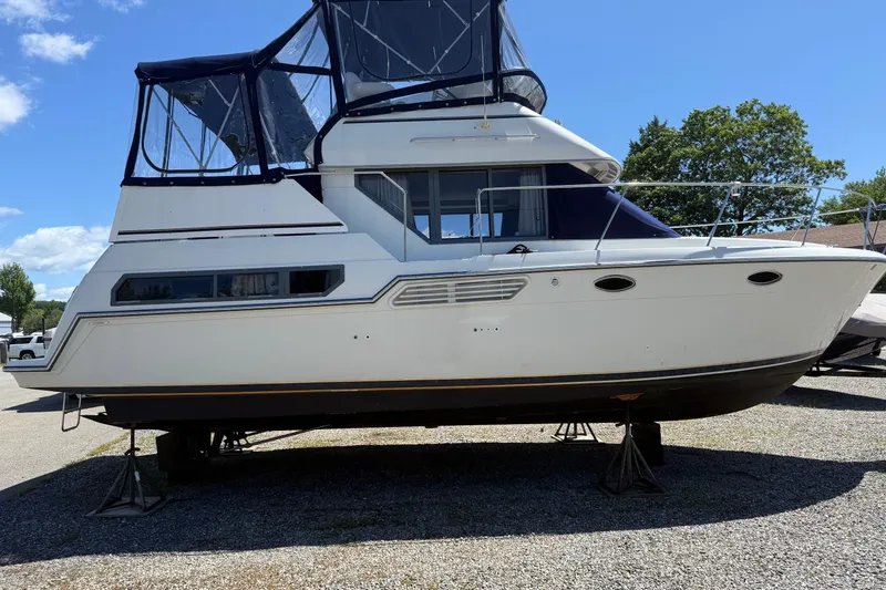 Slide: The Image of 1995 Carver 325 Aft Cabin boat on stands, blue sky background. - 28