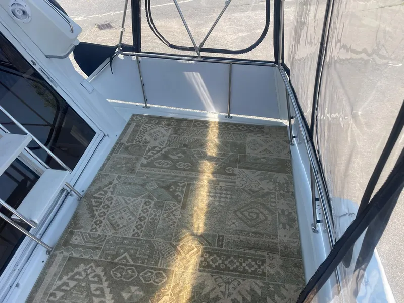Slide: The Image of 1995 Carver 325 Aft Cabin boat interior with patterned carpet and clear enclosure. - 9
