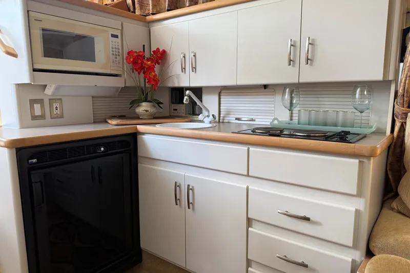 Slide: The Image of Compact kitchen in a 1995 Carver 325 Aft Cabin yacht with microwave, sink, and stove. - 13