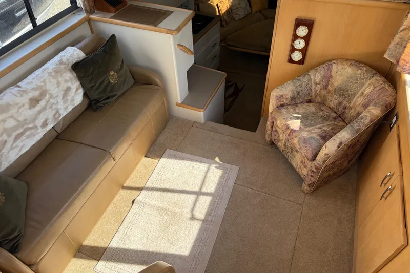 Slide: The Image of Interior of 1995 Carver 325 Aft Cabin with sofa, armchair, and carpeted floor. - 17