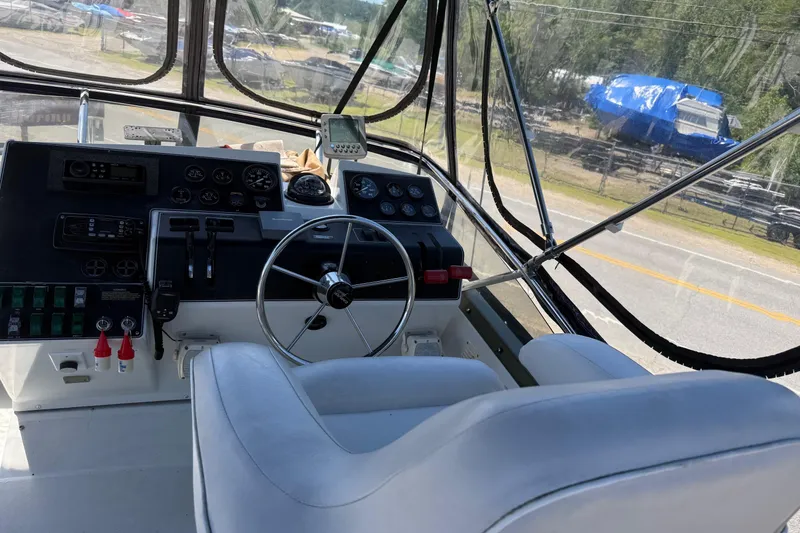 Slide: The Image of 1995 Carver 325 Aft Cabin helm with steering wheel and control panel. - 24