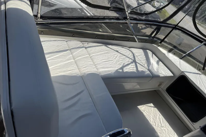 Slide: The Image of 1995 Carver 325 Aft Cabin interior with white seating and clear enclosure. - 25