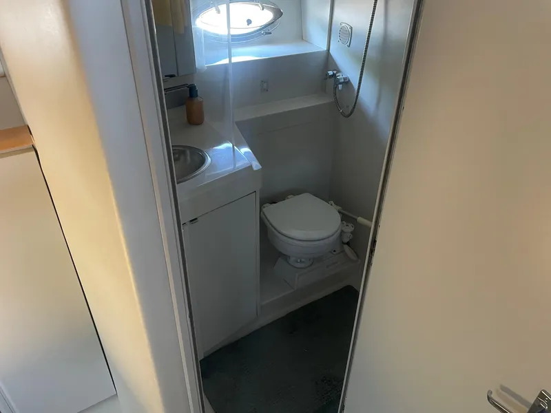 Slide: The Image of Compact bathroom in a 1995 Carver 325 Aft Cabin yacht, featuring a toilet and sink. - 4