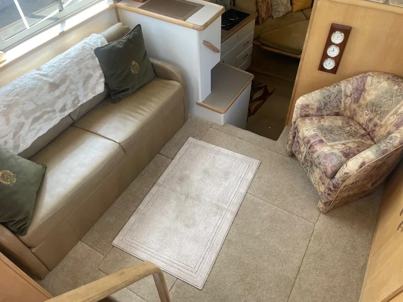 Slide: The Image of Interior of 1995 Carver 325 Aft Cabin with beige sofa, patterned chair, and carpet. - 7