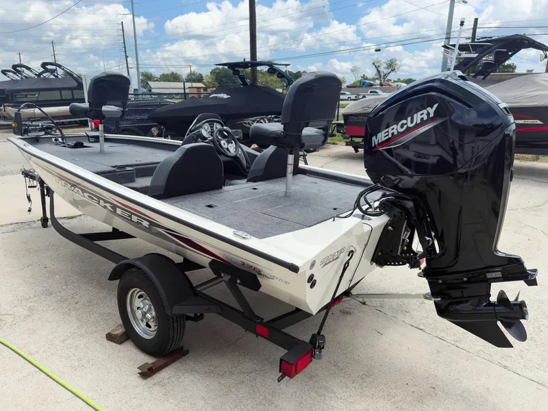 Slide: The Image of 2024 Tracker Pro Team 175 TXW boat with Mercury engine, parked outdoors. - 6