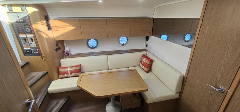 Slide: The Image of Interior of 2015 Beneteau 38 Gran Tourismo yacht with cozy seating and wooden accents. - 17