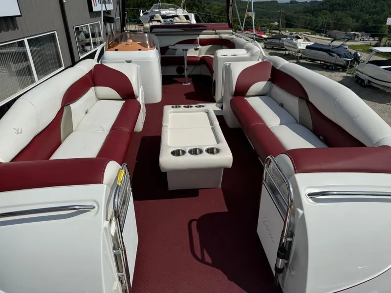 Slide: The Image of 2006 JC 266 TriToon Classic I/O boat with spacious seating and cup holders, docked outdoors. - 12