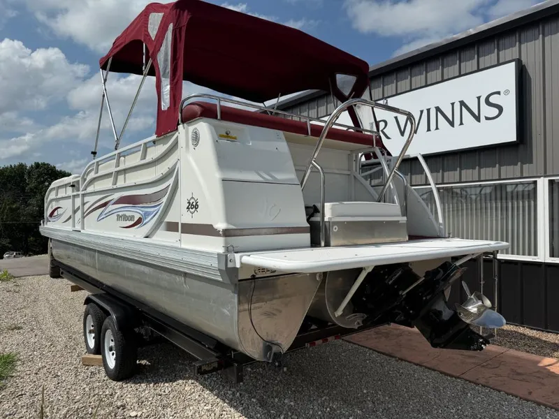 Slide: The Image of 2006 JC 266 TriToon Classic I/O boat with red canopy on a trailer. - 3