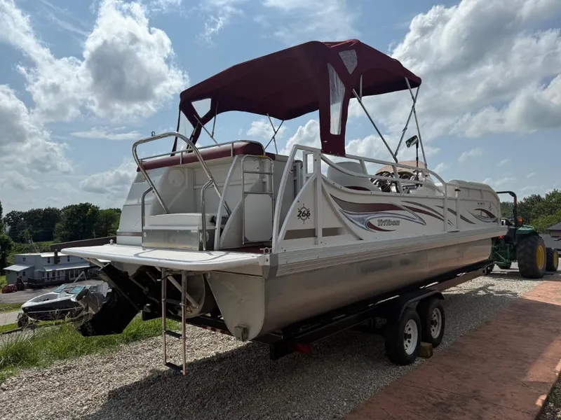Slide: The Image of 2006 JC 266 TriToon Classic I/O pontoon boat on trailer under cloudy sky. - 4
