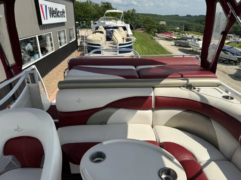 Slide: The Image of 2006 JC 266 TriToon Classic I/O boat with red and white seating near Wellcraft dealership. - 6