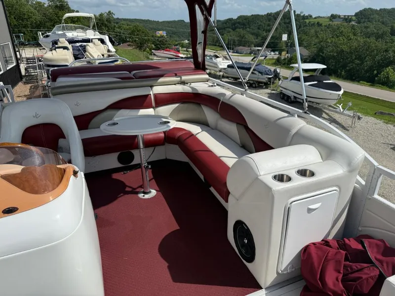 Slide: The Image of 2006 JC 266 TriToon Classic I/O boat with red and white seating, outdoor setting. - 9