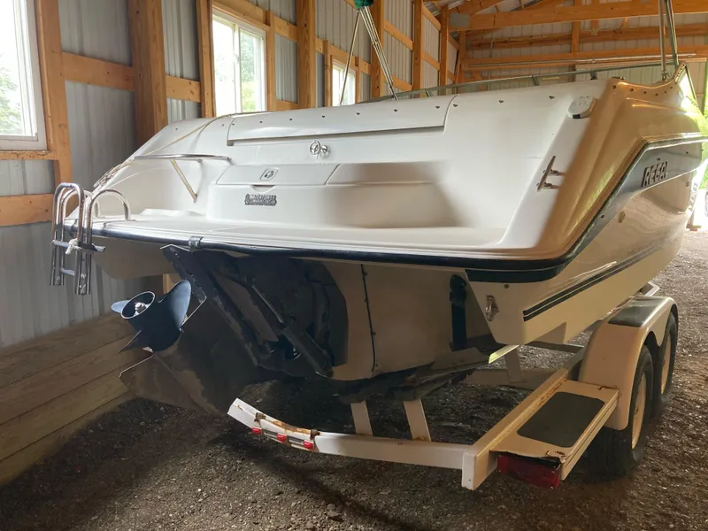 Slide: The Image of 1996 Regal 7.0 SE boat on trailer in a wooden storage shed. - 2